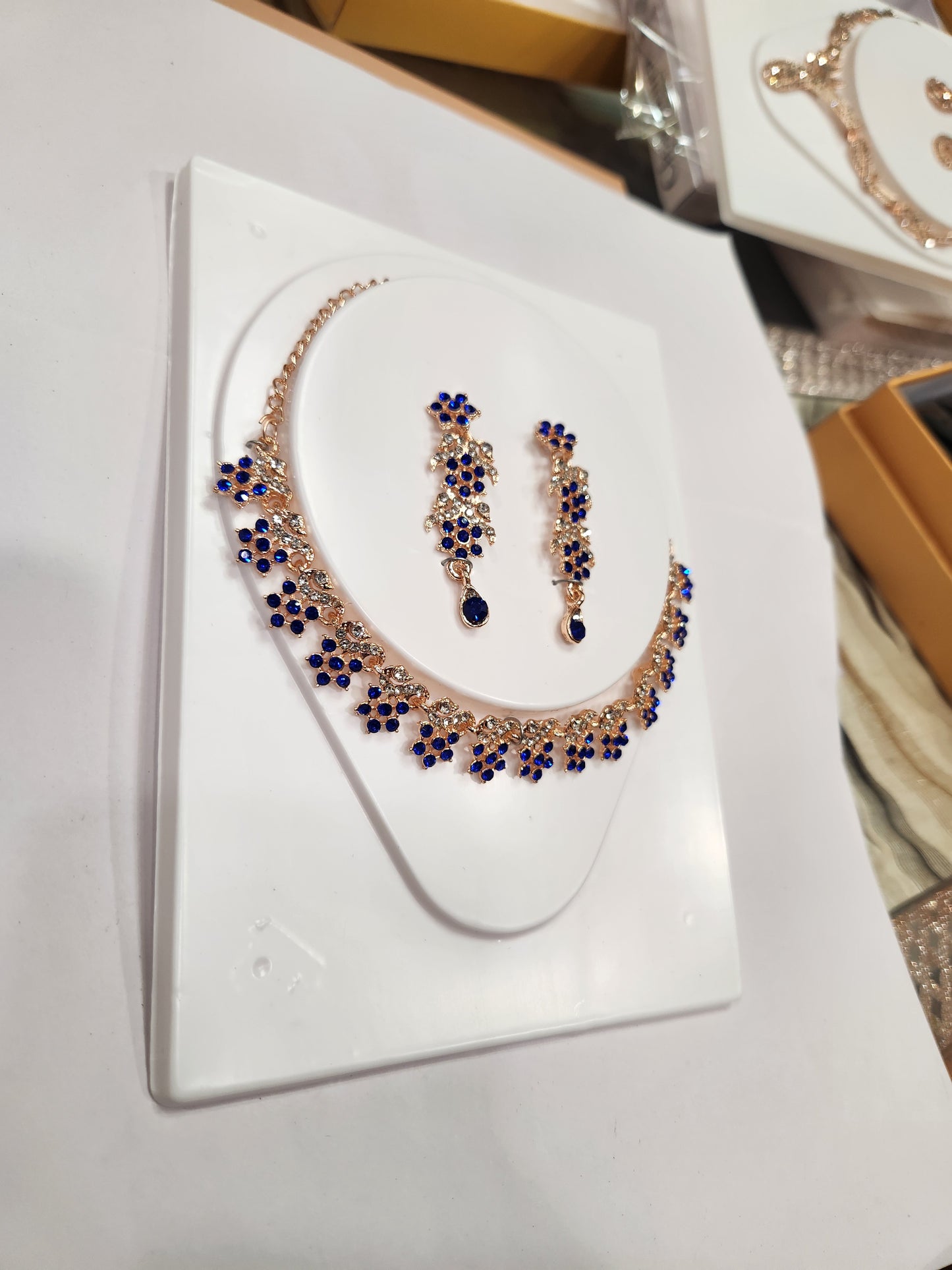 Elegant blue and white rhinestone studded necklace set with long drop earrings having flower shaped pieces