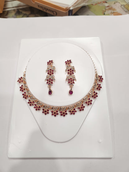 Elegant red and white rhinestone necklace set with flower-shaped drop earrings.