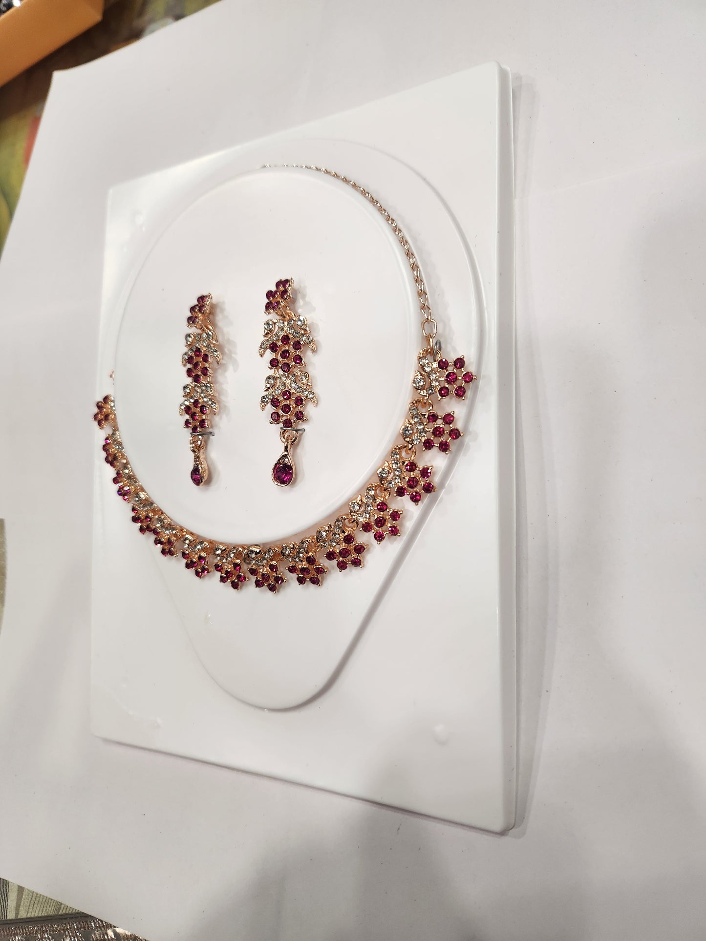 Elegant red and white rhinestone necklace set with flower-shaped drop earrings.