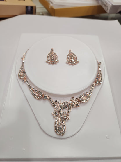 Elegant asymmetric white rhinestone necklace set with drop-shaped earrings, perfect for any attire.