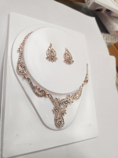 Elegant asymmetric white rhinestone necklace set with drop-shaped earrings, perfect for any attire.