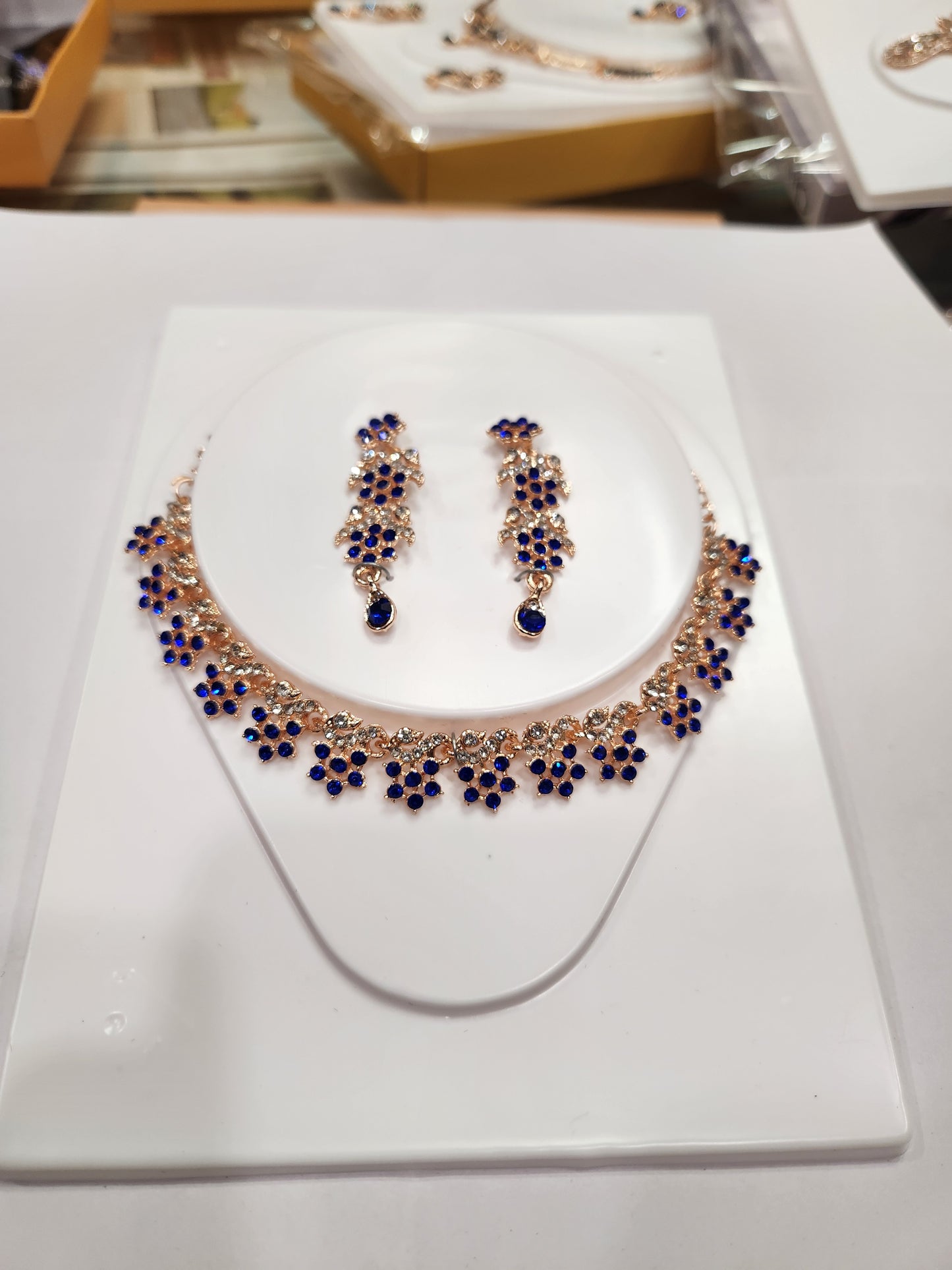 Elegant blue and white rhinestone studded necklace set with long drop earrings having flower shaped  pieces